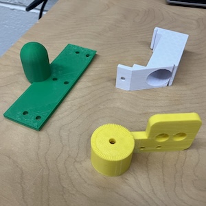 Three robot parts that were 3d-printed.